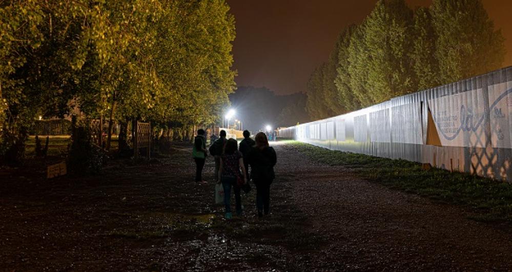 Mise en lumière du chantier de Clichy-Montfermeil de nuit dans le cadre du projet de Théodora Barat pour la nuit blanche, passants aux abords du chantier