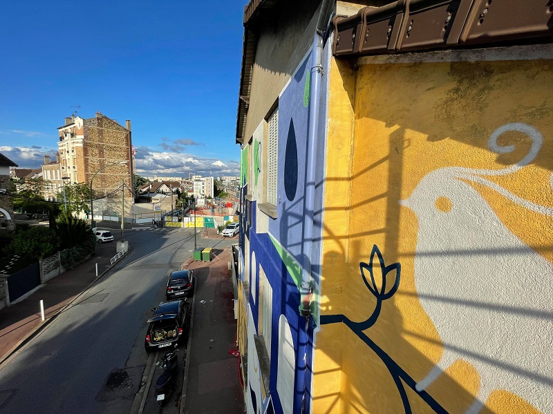Fresque sur la façade d’une maison dans l’esprit d’une bande dessinée, avec des couleurs vert, bleu, blanc et jaune, à Clamart dans le cadre du chantier partagé « Détours » mené par les collectifs Beat and Beer et Crème Fraîche 