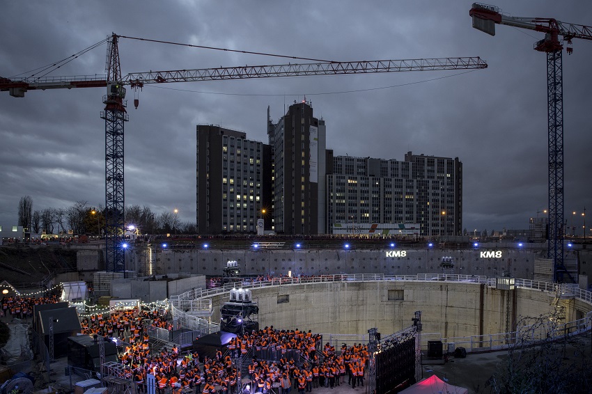 La foule en gilets orange de chantiers rassemblée de nuit autour du puits du chantier de la future gare Villejuif Institut Gustave-Roussy lors du KM8