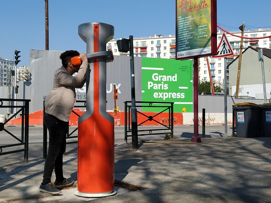 Un usager teste la borne de réalité virtuelle aux abords du chantier de la future gare de Bagneux, devant les palissades du chantier