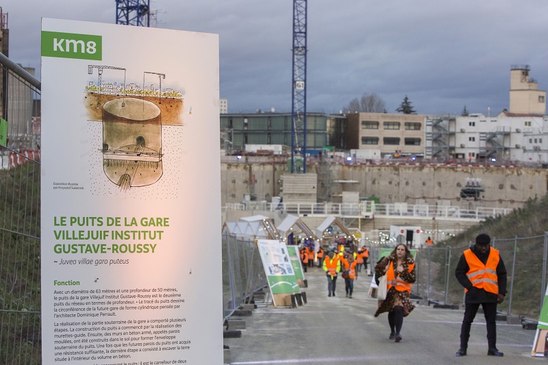 Panneau illustré de présentation du puits de la gare dans une allée du chantier de la future gare de Villejuif Institut Gustave-Roussy 
