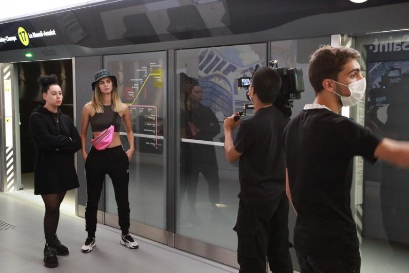 Quatre personnes tournent une scène sur une maquette à échelle 1 du futur quai de gare du Grand Paris Express, à la Fabrique du métro 
