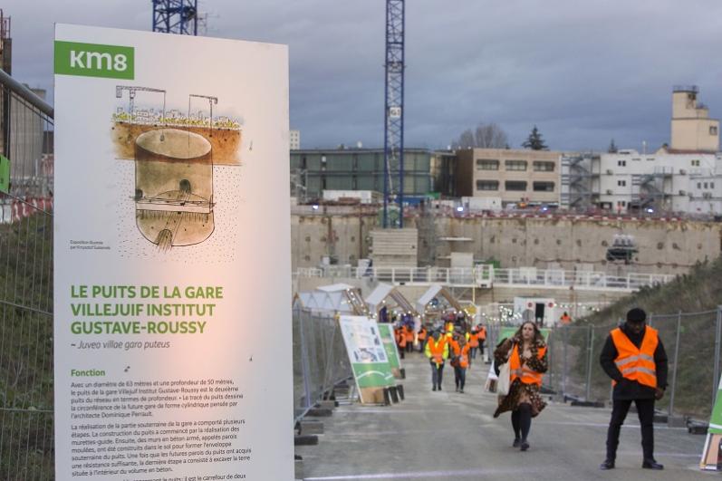 Panneau illustré de présentation du puits de la gare dans une allée du chantier de la future gare de Villejuif Institut Gustave-Roussy 